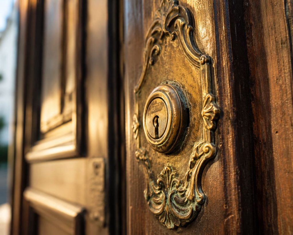Ornamentaler Messingbeschlag mit vintage Schloss an traditioneller Holztür im Münchner Stadtteil Schwabing